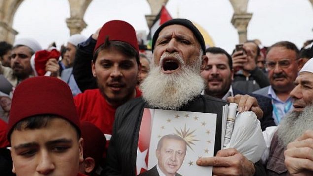 المصلون المسلمون يحملون صورة للرئيس التركي رجب طيب أردوغان بعد صلاة ظهر يوم الجمعة في المسجد الأقصى للقدس القديمة في جبل القدس، 22 ديسمبر / كانون الأول 2017. (AFP Photo/Ahmad Gharabli)