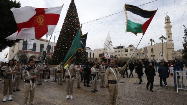 الكشافة المسيحيةي الفلسطينية تقدم عرضا في ساحة المهد خارج كنيسة المهد مع احتشاد المحتفلين بعيد الميلاد في مدينة بييت لحم في الضفة الغربية، 24 ديسمبر، 2017. ( AFP PHOTO / HAZEM BADER) الكشافة المسيحيةي الفلسطينية تقدم عرضا في ساحة المهد خارج كنيسة المهد مع احتشاد المحتفلين بعيد الميلاد في مدينة بييت لحم في الضفة الغربية، 24 ديسمبر، 2017. ( AFP PHOTO / HAZEM BADER)