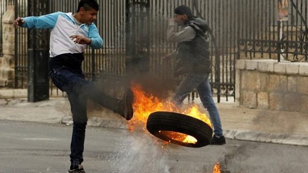 يشن متظاهر فلسطيني اطار مشتعل اثناء اشتباكات مع القوات الاسرائيلية في مدينة بيت لحم بالضفة الغربية في 29 كانون الاول 2017 بعد صلاة الجمعة. (AFP / Musa al Shaer)