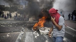 شبان فلسطينيون يحملون حجارة خلال مواجهات مع الشرطة الإسرائيلية في حي صور باهر الواقع في القدس الشرقية، 7 أكتوبر، 2017. (Hadas Parush/Flash90)