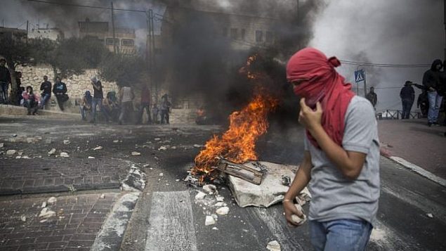 شبان فلسطينيون يحملون حجارة خلال مواجهات مع الشرطة الإسرائيلية في حي صور باهر الواقع في القدس الشرقية، 7 أكتوبر، 2017. (Hadas Parush/Flash90)