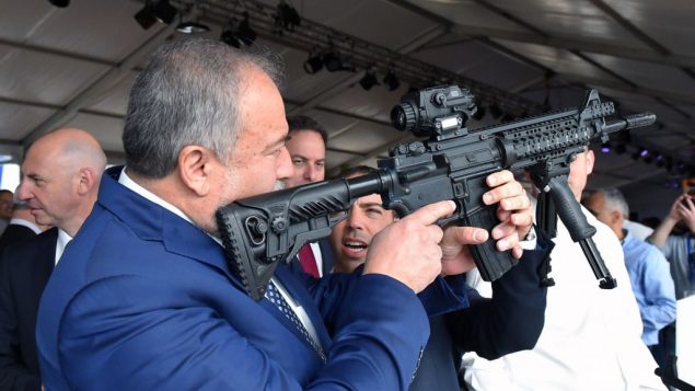 وزير الدفاع افيغادور ليبرمان يفحص بندقية في مصع اسلحة في مدينة سديروت الجنوبية، 14 ديسمبر 2017 (Ariel Hermoni/Defense Ministry)