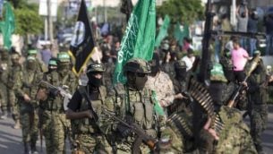 مسلحون فلسطينيون من ’كتائب عز الدين القسام’، الجناح العسكري لحركة ’حماس’ الفلسطينية، يشاركون في مسيرة عسكرية ضد إسرائيل في مدينة غزة، 25 يوليو، 2017. (AFP PHOTO / MAHMUD HAMS)
