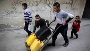يحمل الأطفال الفلسطينيون المياه في مخيم الشاطئ للاجئين في مدينة غزة في 4 يناير / كانون الثاني 2018. (AFP PHOTO / MOHAMMED ABED)