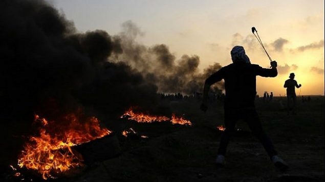 فلسطينيون في اشتباكات مع قوات الأمن الإسرائيلية في الضواحي الشرقية لمدينة غزة، بالقرب من الحدود مع إسرائيل، في 12 يناير / كانون الثاني 2018. (AFP Photo/Mohammed Abed)