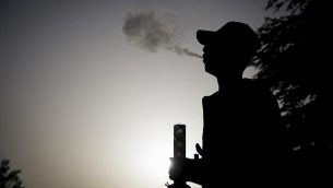 إسرائيلي يقف في حديقة الورود المقابلة للكنيست خلال اليوم العالم لتدخين الماريجوانا في القدس، 20 أبريل، 2017. (Yonatan Sindel/Flash90) إسرائيلي يقف في حديقة الورود المقابلة للكنيست خلال اليوم العالم لتدخين الماريجوانا في القدس، 20 أبريل، 2017. (Yonatan Sindel/Flash90)