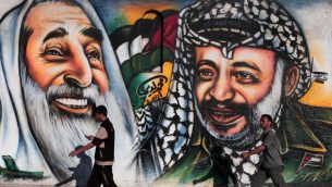 فلسطينيون يمرون بجدار يصور الرئيس الفلسطيني الراحل ياسر عرفات في مدينة غزة يوم الأربعاء 4 يوليو / تموز 2012. (Wissam Nassar/Flash90)