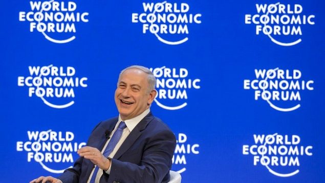 رئيس الوزراء بينيامين نتنياهو يضحك خلال مؤتمر في منتدى الاقتصاد العالمي السنوي في دافوس، 21 يناير، 2016. (AFP/FABRICE COFFRINI)