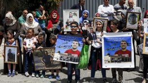 أسر أسرى فلسطينيين في السجون الإسرائيلية يتظاهرون أمام مكاتب الإتحاد الأوروبي في القدس الشرقية، 27 أبريل، 2017. (AFP/AHMAD GHARABLI)