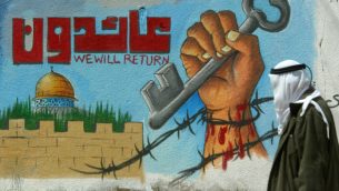 رجل فلسطيني يمر امام جدارية تنادي لعودة اللاجئين الفلسطينيين (Abed Rahim Khatib/Flash90)