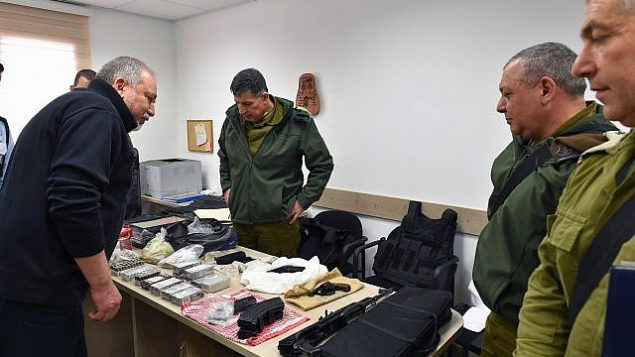وزير الدفاع أفيغدور ليبرمان، من اليسار، يلقي نظرة على الأسلحة والمعدات العسكرية التي صودرت في عملية للجيش الإسرائيلي في الخليل، إلى جانب قائد المنطقة الوسطى المنتهية ولايته روني نوما، خلال جولة في مدينة الخليل، 27 فبراير، 2018. (Ariel Hermoni/Defense Minister)