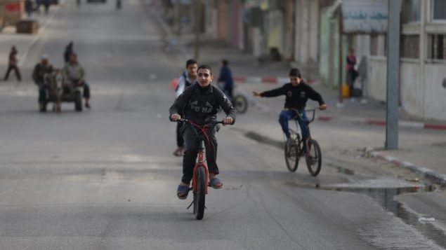 اطفال فلسطينيون يركبون دراجالت هوائية في غزة، 8 مارس 2018 (AFP/ MOHAMMED ABED)