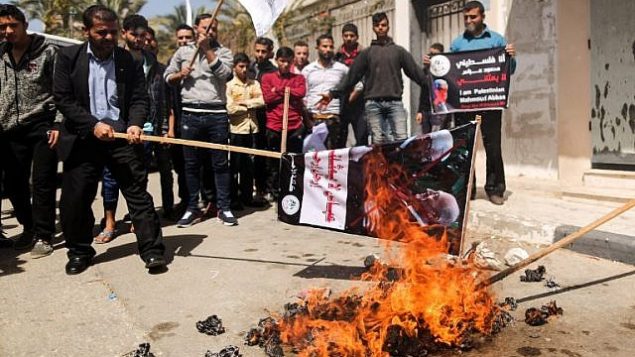 فلسطينيون يحرقون دمية تمثل رئيس السلطة الفلسطينية محمود عباس خلال تظاهرة في غزة في 21 مارس، 2018، احتجاجا على تصريحاته التي اتهم فيها حركة حماس بالوقوف وراء التفجير الذي استهدف موكب رئيس الحكومة الفلسطيني رامي الحمد الله في غزة في الأسبوع الماضي. (AFP PHOTO / MAHMUD HAMS)