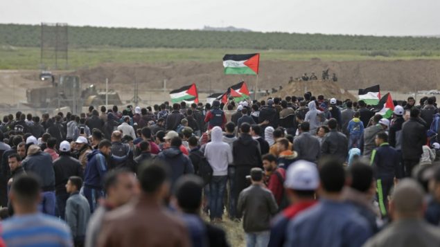 فلسطينيون يتظاهرون بالقرب من الحدود مع اسرائيل، شرقي مدينة غزة، في يوم الاربض، 30 مارس 2018 (MAHMUD HAMS / AFP)