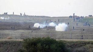 توضيحية: متظاهرون فلسطينيون بالقرب من السياج الحدود الإسراءئيلي مع قطاع غزة والجيش الإسرائيلي يطلق قنابل الغاز المسيل للدموع باتجاههم، 3 يناير، 2014. (David Buimovitch/Flash90)