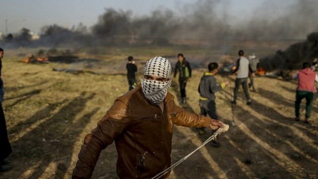 متظاهر فلسطيني يستخدم مقلاعًا لإلقاء حجر خلال اشتباكات مع القوات الإسرائيلية في أعقاب تجمع معسكر الخيام على الحدود بين إسرائيل وغزة شرق مدينة غزة في 4 أبريل 2018. (AFP MAHMUD HAMS)