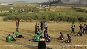 فلسطينيون ذوي اعاقات يلعبون الكرة الطائرة بالقرب من موقع الاشتباكات بين متظاهرين فلسطينيين وقوات الامن الإسرائيلية في اعقاب مظاهرات امام الحدود بين غزة واسرائيل، شرقي مدينة غزة، 5 ابريل 2018 (AFP/MOHAMMED ABED)