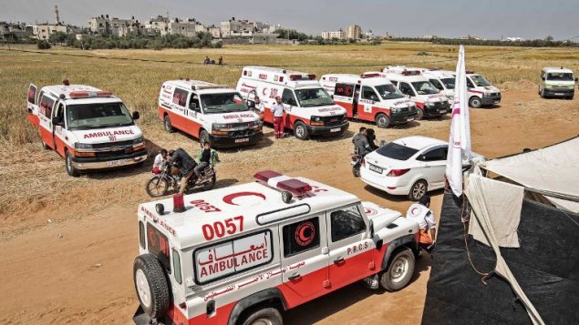مسعفون فلسطينيون يتهيأون خلال مظاهرات  امام الحدود بين غزة واسرائيل بالقرب من خان يونس، شرقي مدينة غزة، 6 ابريل 2018 (SAID KHATIB / AFP)
