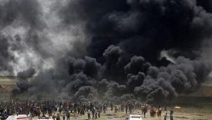 فلسطينيون يحرقون إطارات في السياج الحدودي مع إسرائيل،  شرق جباليا في وسط مدينة غزة، خلال مظاهرة في 13 أبريل، 2018. (AFP PHOTO / MOHAMMED ABED)