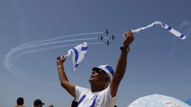إسرائيليون يشاهدون عرض طيران خلال الاحتفالات بيوم الاستقلال ال70 لبلادهم، في 19 أبريل، 2018، في مدينة تل أبيب.(AFP PHOTO / Ahmad GHARABLI)