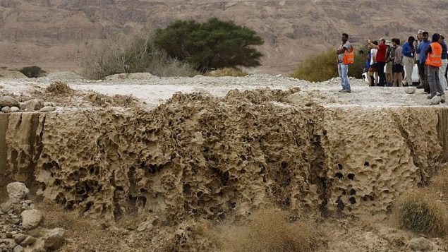 اسرائيليون يراقبون مياه جرف سدت طريق رئيسي بالقرب من البحر الميت، في اعقاب امطار عزيرة في الجبال المحيطة، 25 ابريل 2018 (AFP PHOTO / MENAHEM KAHANA) اسرائيليون يراقبون مياه جرف سدت طريق رئيسي بالقرب من البحر الميت، في اعقاب امطار عزيرة في الجبال المحيطة، 25 ابريل 2018 (AFP PHOTO / MENAHEM KAHANA)