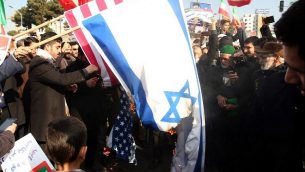 مؤيدو الحكومة الإيرانية يحرقون الأعلام الإسرائيلية والأمريكية خلال مسيرة في مشهد لدعم النظام بعد أن أعلنت السلطات نهاية الاحتجاجات الأخيرة، في 4 يناير  2018. (AFP Photo/Tasnim News/Nima Najafzadeh)