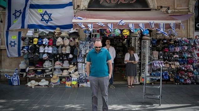 أشخاص يقفون بصمت في شارع يافا في وسط مدينة القدس مع سماع صفارات الإنذار لمدة دقيقتين في جميع أنحاء إسرائيل لإحياء ذكرى المحرقة في 12 أبريل، 2018. (Yonatan Sindel/Flash90)