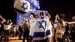 أشخاص يشاهدون غرض الألعاب النارية احتفالا بيوم استقلال إسرائيل ال70 في تل أبيب، 18  أبريل، 2018. (Miriam Alster/Flash90)