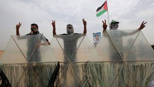 فلسطينيون يقفون وراء الطائرات الورقية قبل أن يحاولوا ارسالها عبر السياج الحدودي مع إسرائيل، في خان يونس في جنوب قطاع غزة في 4 مايو 2018. اعتمد الفلسطينيون الذين شاركوا في الاشتباكات الأسبوعية على الحدود تكتيكًا جديدًا لتحميل قنابل حارقة بالطائرات الورقية التي تحلق فوق السياج الحدودي داخل إسرائيل. (AFP Photo/Said Khatib)