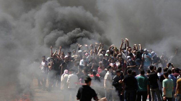 متظاهرو فلسطينيون يحرقون الإطارات بالقرب من الحدود بين إسرائيل وغزة، شرقي مدينة غزة، 14 مايو، 2018.   (AFP PHOTO / MAHMUD HAMS)