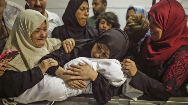والدة ليلى الغندور تحملها في مشرحة مستشفى الشفا في غزة، 15 مايو 2018 (AFP / MAHMUD HAMS)