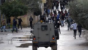صورة توضيحية: شبان فلسطينيون يرشقون حجارة باتجاه قوات الامن الإسرائيلية خلال عملية عسكرية في مدينة جنين في الضفة الغربية، 18 يناير 2018 (AFP/Jaafar Ashtiyeh)