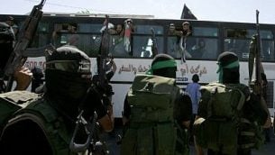 توضيحية: أعضاء في حركة حماس يستقبلون حافلة تقل أسرى فلسطينيين تصل إلى معبر رفح مع مصر في جنوب قطاع غزة، 18 أكتوبر، 2011. (Abed Rahim Khatib/Flash 90)