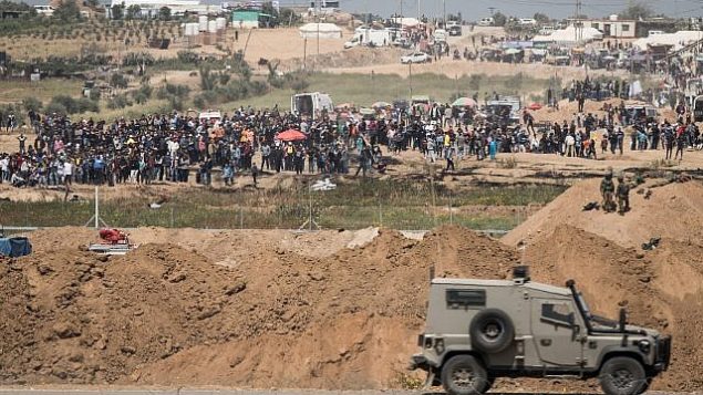 جنود إسرائيليون على الجانب الإسرائيلي من الحدود مع قطاع غزة، خلال مظاهرة لآلاف الفلسطينيين بالقرب من السياج الحدودي، 6 أبريل، 2018. (Hadas Parush/Flash90)