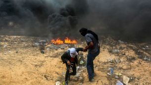 متظاهرون فلسطينيون خلال اشتباكات مع القوات الإسرائيلية بالقرب من الحدود بين اسرائيل وقطاع غزة في رفح، 14 مايو 2018 (Abed Rahim Khatib/Flash90)