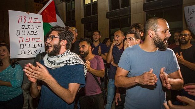 نشطاء يتظاهرون ضد اعتقال 21 شخصا خلال تظاهرة ليلة الجمعة، من أمام محكمة الصلح في مدينة حيفا، 20 مايو، 2018. (Meir Vaknin/Flash90)
