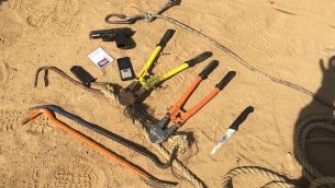 مسدس وسكين وقضبان حديدية تم العثور عليها بحوزة ثمانية مسلحين يُشتبه بانتمائهم لحركة حماس يقول الجيش إنهم قاموا بفتح النار على قوات إسرائيلية في شمال قطاع غزة، 14 مايو، 2018. (Israel Defense Forces)