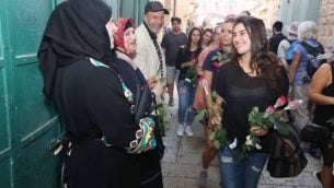 خلال مسيرة للسلام نظمتها منظمة "تاغ مئير" شابة توزع ورودا على أصحاب متاجر عرب في البلدة القديمة في القدس قبيل ’مسيرة العلم’، 24 مايو، 2017.  (Courtesy)