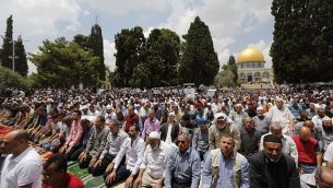 يصلي المسلمين بالقرب من قبة الصخرة والمسجد الأقصى، خلال صلاة الجمعة الثالثة من شهر رمضان المبارك في 1 يونيو 2018. (AFP Photo/Ahmad Gharabli)