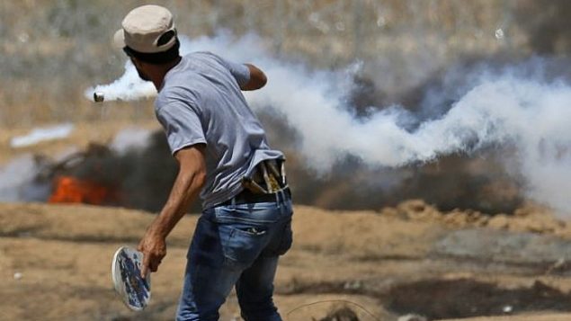 فلسطيني يستخدم مضربًا خشبيًا لإطلاق عبوة غاز مسيل للدموع خلال مواجهات مع القوات الإسرائيلية بالقرب من الحدود مع إسرائيل، شرق خان يونس في جنوب قطاع غزة، في 8 يونيو / حزيران 2018. (AFP Photo / Said Khatib) فلسطيني يستخدم مضربًا خشبيًا لإطلاق عبوة غاز مسيل للدموع خلال مواجهات مع القوات الإسرائيلية بالقرب من الحدود مع إسرائيل، شرق خان يونس في جنوب قطاع غزة، في 8 يونيو / حزيران 2018. (AFP Photo / Said Khatib)