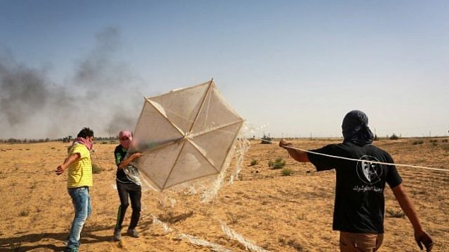 فلسطينيون يعدون طائرة ورقية محملة بمواد حارقة سيقومون بإطلاقها باتجاه جنود إسرائيل من رفح، في جنوب قطاع غزة، 22 يونيو، 2018.  (Abed Rahim Khatib/Flash90)