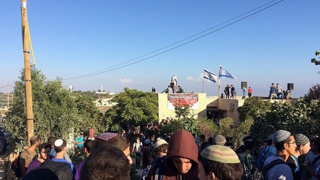 محتجون في بؤرة نتيف هأفوت الاستيطانية في في بؤرة نتيف هأفوت الاستيطانية الواقعة في منطقة غوش عتصيون في الضفة الغربية قبيل البدء بهدم 15 منزلا تم بناؤها بصورة غير قانونية على أرض فلسطينية، 12 يونيو، 2018  (Luke Tress/Times of Israel)