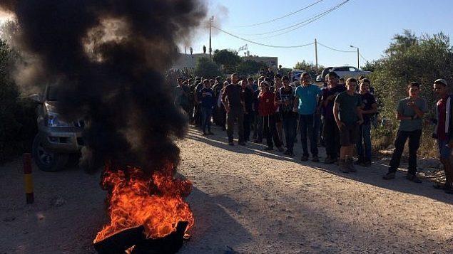 محتجون في بؤرة نتيف هأفوت الاستيطانية في منطقة غوش عتصيون في الضفة الغربية قبيل البدء بهدم 15 منزلا تم بناؤها بصورة غير قانونية على أرض فلسطينية، 12 يونيو، 2018.  (Luke Tress/Times of Israel)