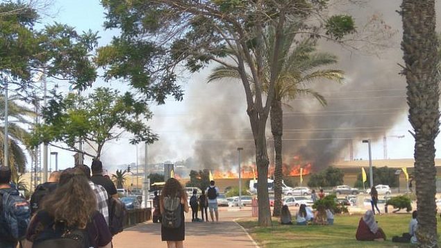 طلاب في كلية سابير في مدينة سديروت يشاهدون حريق كبير في كيبوتس نير عام في جنوب اسرائيل، على ما يبدو نتج عن ’طائرة ورقية حارقة’ اطلقت من قطاع غزة، 5 يونيو 2018 (Tair Alush)