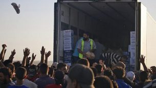 سوريون نازحون فروا من قصف قوات النظام السوري في درعا، يتجمعوت للحصول على مساعدات غذائية في مخيم بالقرب من الحدود الاردنية وبلدة نصيب، جنوب سوريا، 2 يوليو 2018 (AFP PHOTO / Mohamad ABAZEED)