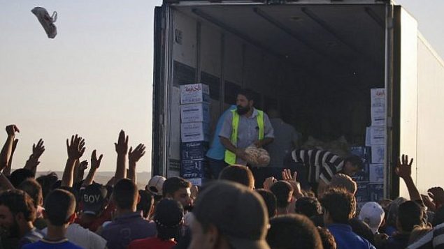سوريون نازحون فروا من قصف قوات النظام السوري في درعا، يتجمعوت للحصول على مساعدات غذائية في مخيم بالقرب من الحدود الاردنية وبلدة نصيب، جنوب سوريا، 2 يوليو 2018 (AFP PHOTO / Mohamad ABAZEED)