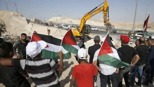 متظاهرون يلوحون بالأعلام الفلسطينية اثناء مظاهرة ضد هدم قرية الخان الأحمر البدوية في الضفة الغربية في 4 يوليو 2018 (AFP Photo/Abbas Momani)
