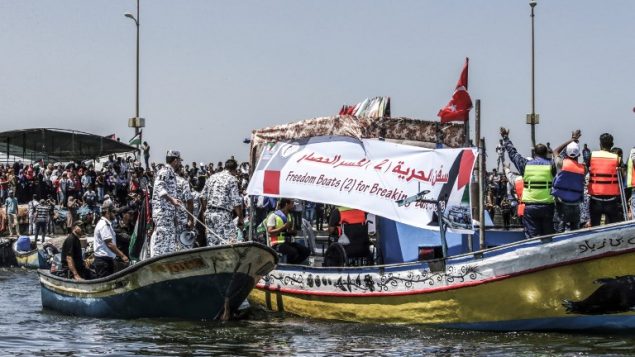 ناشطون يرافقون قارب على متنه فلسطينيين اصيبوا خلال الاشتباكات عند السياج الامني حول غزة، اثناء محاولته كسر الحصار البحري الذي تفرضه اسرائيل، 10 يوليو 2018 (Mahmud Hams/AFP)