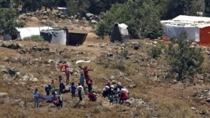 صورة تم  التقاطها في 17 يوليو، 2018 من هضبة الجولان تظهر لاجئين يقتربون من السياج الحدودي بين سوريا وإسرائيل من مخيم للنازحين السوريين بالقرب من بلدة بريقة السورية في محافظة القنيطرة الجنوبية. (AFP /JALAA MAREY)