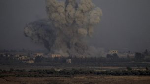 صورة التقطت من الطرف الإسرائيلي في مرتفعات الجولان تظهر الدخان يتصاعد من مباني في الطرف السوري من الحدود خلال غارات جوية سورية في محافظة القنيطرة، 25 يوليو 2018 (AFP / JALAA MAREY)